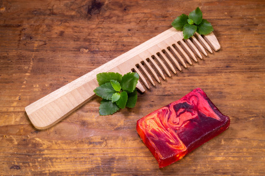 Handmade Soap With A Hairbrush And A Plant On A Wooden Background