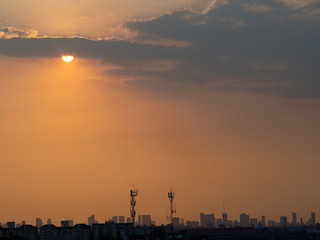 Obraz premium Sunrise over buildings in city. Skyline view of cityscape with sunlight in warm light color tone