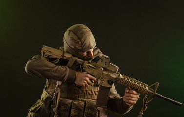 soldier-saboteur in military clothing with weapons on a dark background