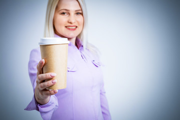 Young beautiful woman drinking paper glass of coffee over isolated white background