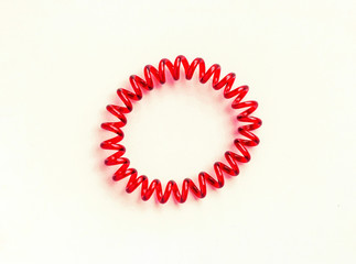 Red spiral rubber bands for hair on a white background close-up