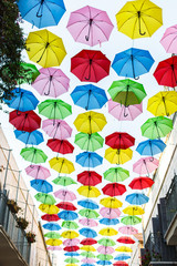 Fototapeta na wymiar sky with umbrellas. Beautiful display of colorful hanging umbrellas along a street. Umbrella Sky. Colorful umbrella roof. Natural tourist attractions Decorated with many umbrellas hanging on the walls