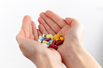 a handful of various colorful pills and vitamin pills