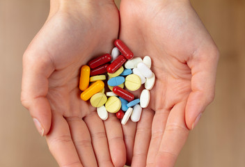 a handful of various colorful pills and vitamin pills