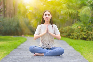 woman sitting and meditating To do yoga and exercise in the morning relax in the park