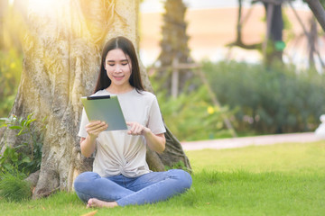 Fototapeta premium Woman use tablet sitting at city park happiness in day time online internet technology