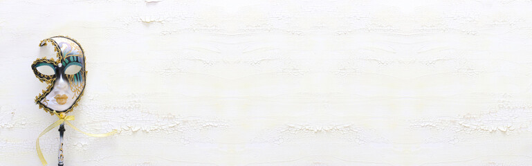 elegant traditional venetian mask over distressed old white wooden background