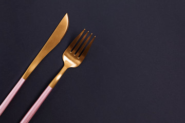 Elegant golden cutlery on black background