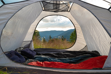 View from the tourist tent on the mountains, meadow, flowers, early in the morning when the sun rises. tourist tent © fotolesnik