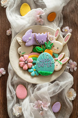 Happy Easter. Multi-colored pastel easter cookies on a wooden background.