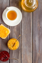 Tea party with jam. Toast, teapot, cup on dark wooden background frame copy space