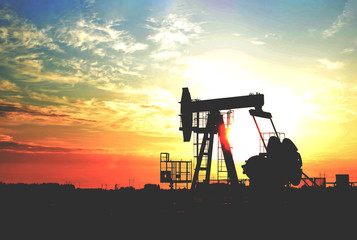 Oil drilling derricks at desert oilfield for fossil fuels output and crude oil production from the ground. Oil drill rig and pump jack. © MaxSafaniuk