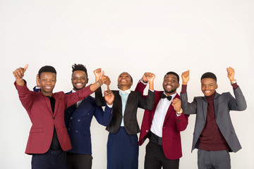 team of young handsome african men and women in suits on a white background with hand gesture