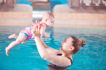 young mother teaches her child to swim