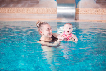 young mother teaches her child to swim