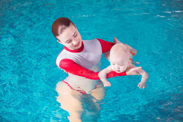 young mother teaches her child to swim