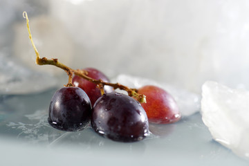 Bunches of grapes in ice water with colorful flashes photographed in studio
