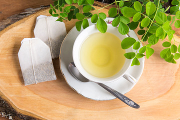 Moringa tea, leaves, seeds, powder on a wooden background - Moringa oleifera