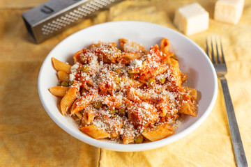 Penne pasta with tomatoes sauce and chicken and parmesan. Italian traditional dish