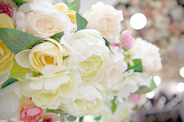 Lots of multicolored blooming roses. Beautiful flowers in bloom. Big bouquet of artificial roses. Flower background.