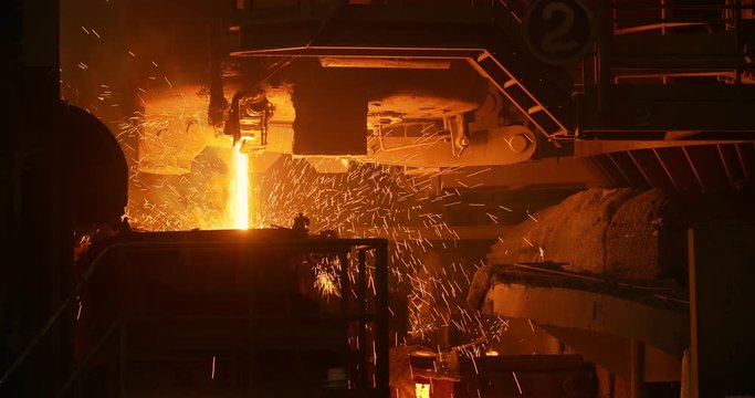 A furnace in which metal is melted. Sparks and smoke from the fire. Metallurgical industry. Car engine factory