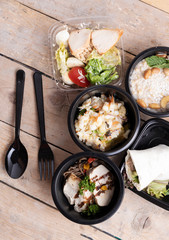 Tasty lunch in plastic containers on wooden table close up