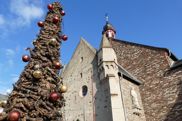 Weihnachtlicher Rebknorzenbaum links mit Kirchenfassade in Rüdesheim am Rhein