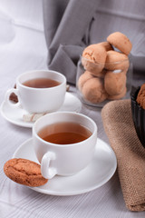 Sweet snacks, cup of tea on light background