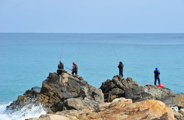 Fototapeta na wymiar Korean fishermen fishing from the rocks on the seashore