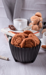 book,cup of tea and chocolate on light background