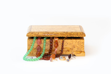 Jasper, agate and nephritis beads in wooden jewelry box and golden and silver rings with gemstones isolated on white background