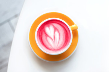 Cup of healthy fresh trendy beetroot latte with latte art on white background. Flat lay style.