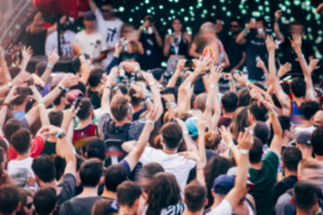 Fototapeta na wymiar Blurred crowd at music festival. Defocused image.