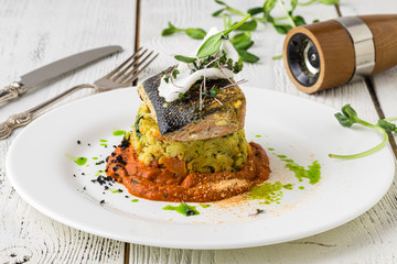 Food - Main course gourmet fish - delicious grilled golden sea bream or dorade with vegetable garnish served on a wooden tabl