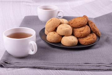 Two white cups of tea with sweeties