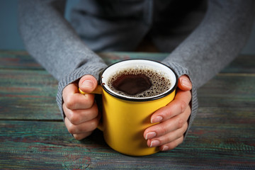 Woman holds a cup of hot tea. Cozy morning at home.