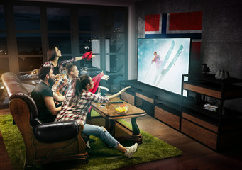 Group of friends watching TV, match, championship, sport games. Emotional men and women cheering for favourite team of skiing in Norway with flag. Concept of friendship, sport, competition, emotions.