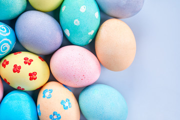 Colorful Easter eggs dyed by colored water with beautiful pattern on a pale blue background, design concept of holiday activity, top view, full frame.