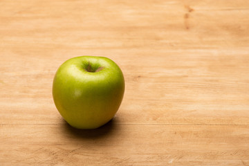 Close up view of green apple on wooden surface