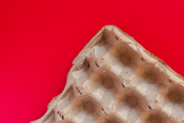 An empty craft egg carton on the red background. View from above. Top view. Copy space