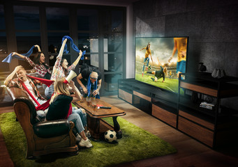 Group of friends watching TV, match, championship, sport games. Emotional men and women cheering...