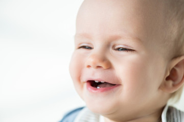 Portrait of laughing baby boy looking away isolated on white