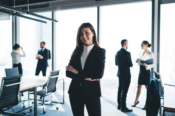 Cheerful Asian manager standing in office