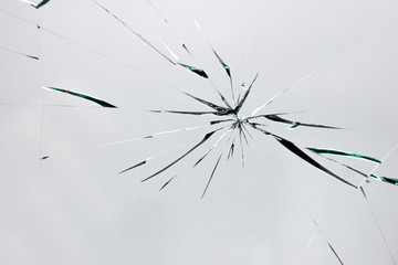 Cracks on broken glass from impact, white crack line fountain on window.