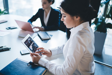 Female manager browsing tablet during meeting
