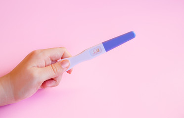 Positive pregnancy test with two strips on pink
