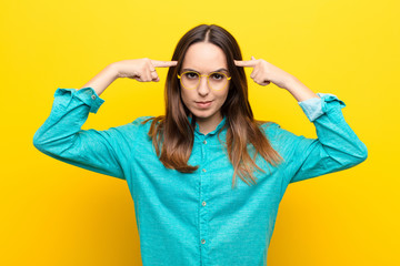 young pretty woman with a serious and concentrated look, brainstorming and thinking about a...