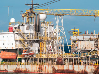 Toned image of old rusty container cargo ship or oil tanker in docks