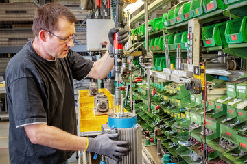 Skilled industrial worker assembling electric motors