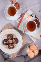 book,sweet snacks and cup of tea on the table